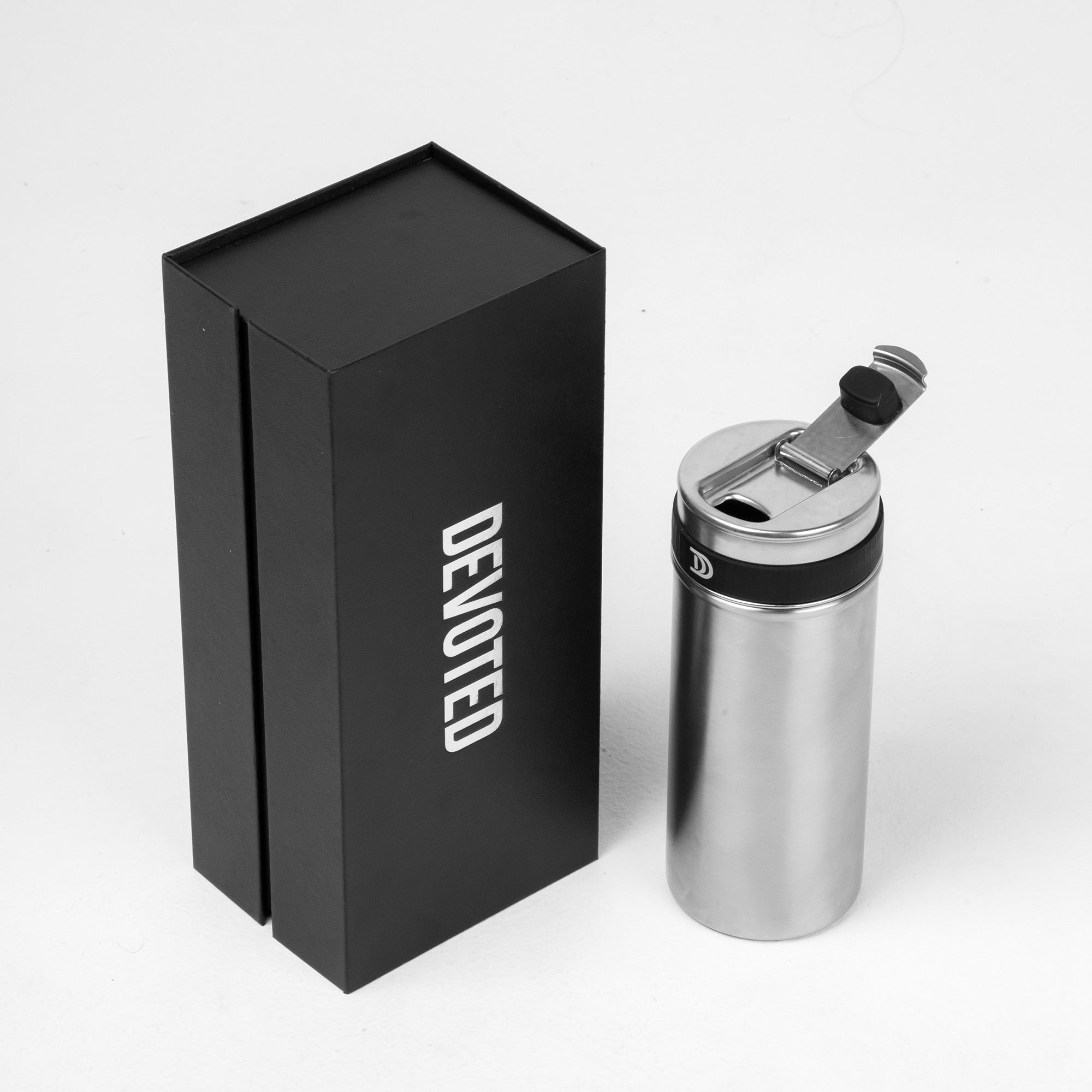 Devoted Steel Shaker silver insulated stainless steel bottle with flip lid next to premium black gift box on white background